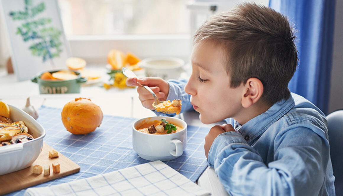 A young boy eating food from a bowl.
