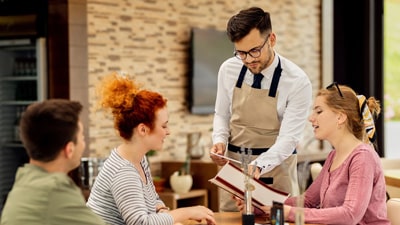 Woman asking her waiter about plant-based options.