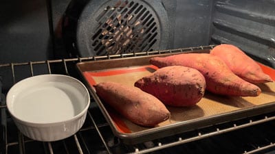 A baking sheet with some sweet potatoes on it