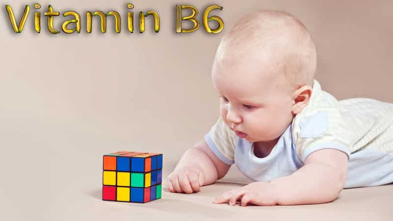 A baby is playing with a rubiks cube.