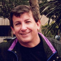 A man with a black jacket and purple collar.