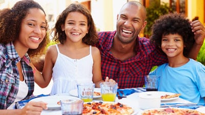 Family eats pizza and drinks soda.