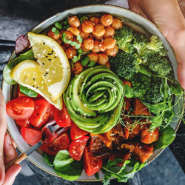 A delicious whole-food, plant-based bowl with chickpeas, tomatoes, broccoli, and other vegetables.
