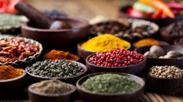 A table filled with bowls of different types of spices.