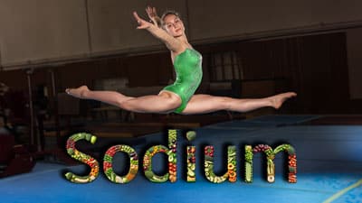 A woman in green leotard jumping on trampoline.