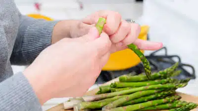 A person holding asparagus in their hands