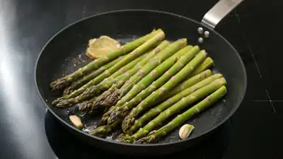 A pan with asparagus and lemon on it.